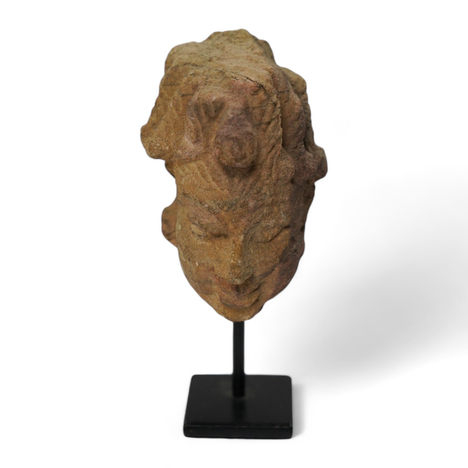 An Indian sandstone head of Shiva, 16th century, 8cm not including stand. Condition - good considering age